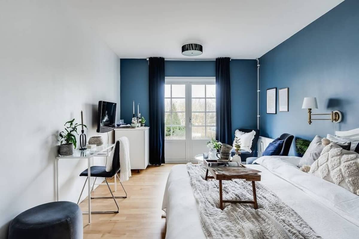 Ein modernes Wohnzimmer mit einer Couch, einem Couchtisch und einem Schreibtisch mit einem Computer.