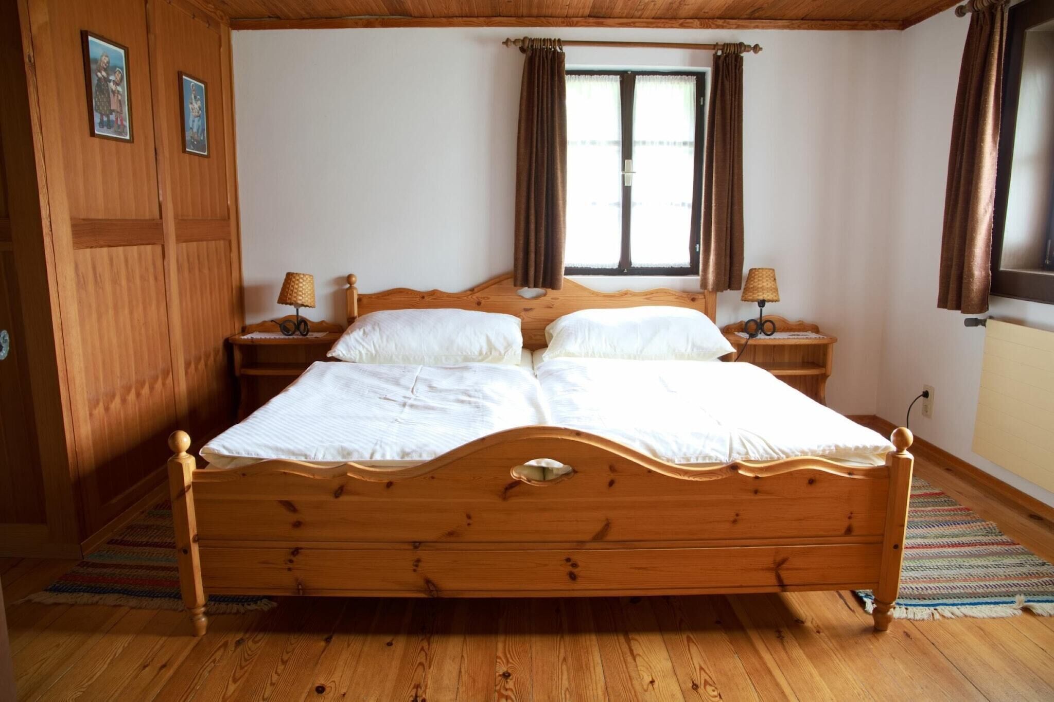 Ein hölzernes Himmelbett mit zwei Nachttischen, einem Vorhangfenster und einer Holzvertäfelung.