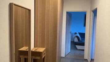 Un couloir avec des armoires en bois et une petite table.