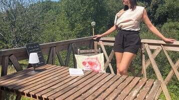A wooden deck with a table, a lamp, and a sign.
