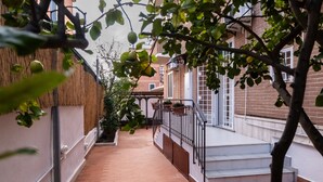 A narrow brick pathway leading to a white staircase with a metal railing. - La Casupola - Gemelli Garden

 (Roma)