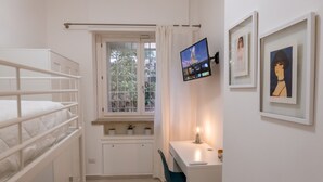 A compact bedroom with bunk beds, a desk with a computer, and a window with a view of trees. - La Casupola - Gemelli Garden

 (Roma)