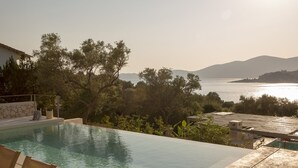 Una piscina infinita con vista al mar y a las montañas.