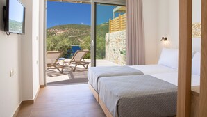 Un dormitorio con cama, televisión y balcón con una silla y mesa.