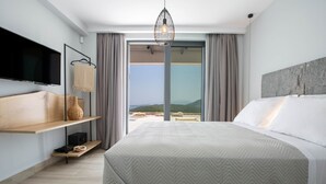 Camera d'albergo moderna con un letto grande, una TV a schermo piatto, un lampadario e vista sull'esterno.