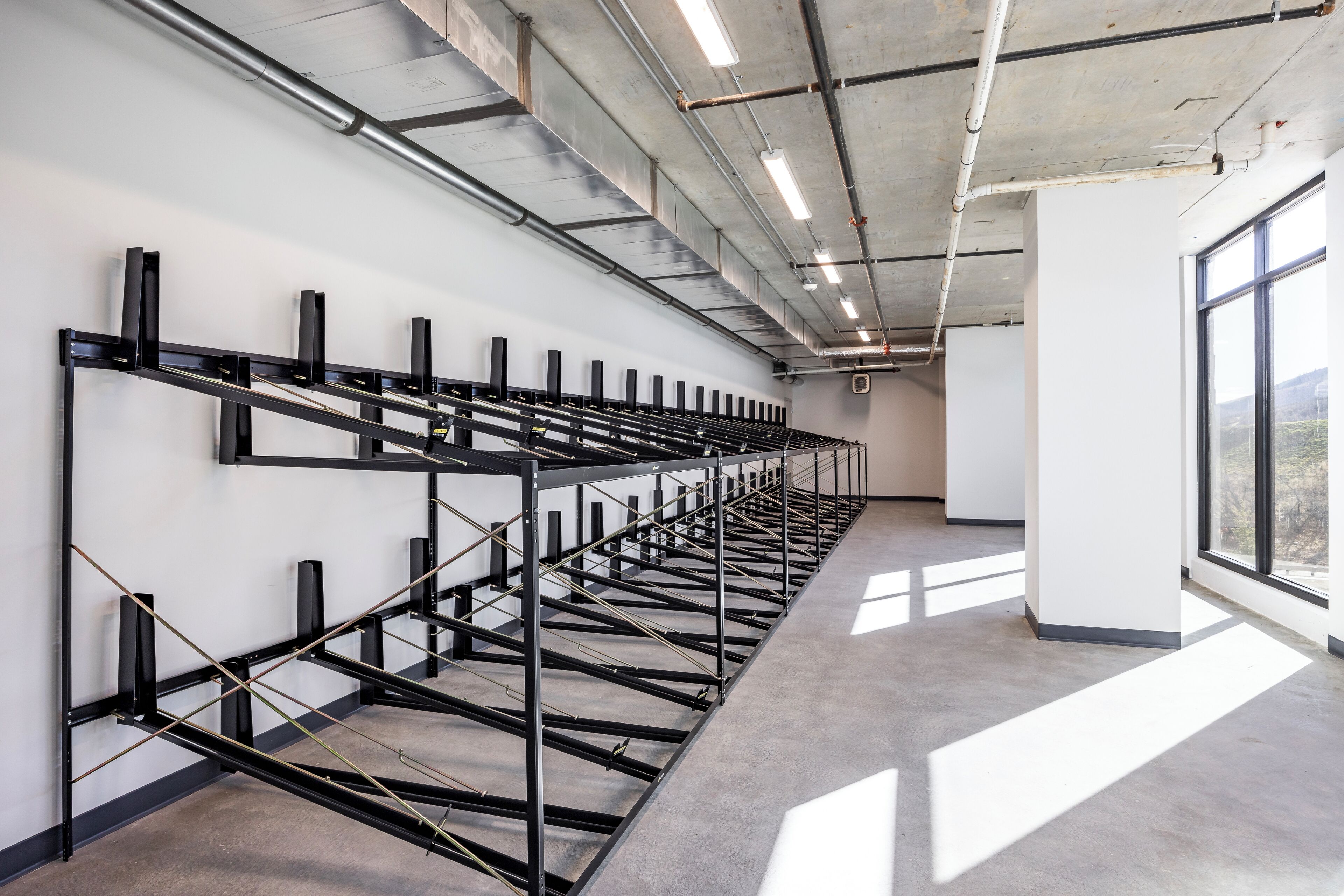Amplia habitación de estilo industrial con un diseño alargado, estructura metálica y suelo de hormigón.