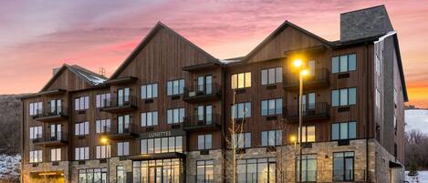A multi-story hotel with a modern design, featuring balconies and large windows.