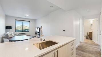 A modern kitchen with a large island, a built-in sink, and a view of the outdoors.