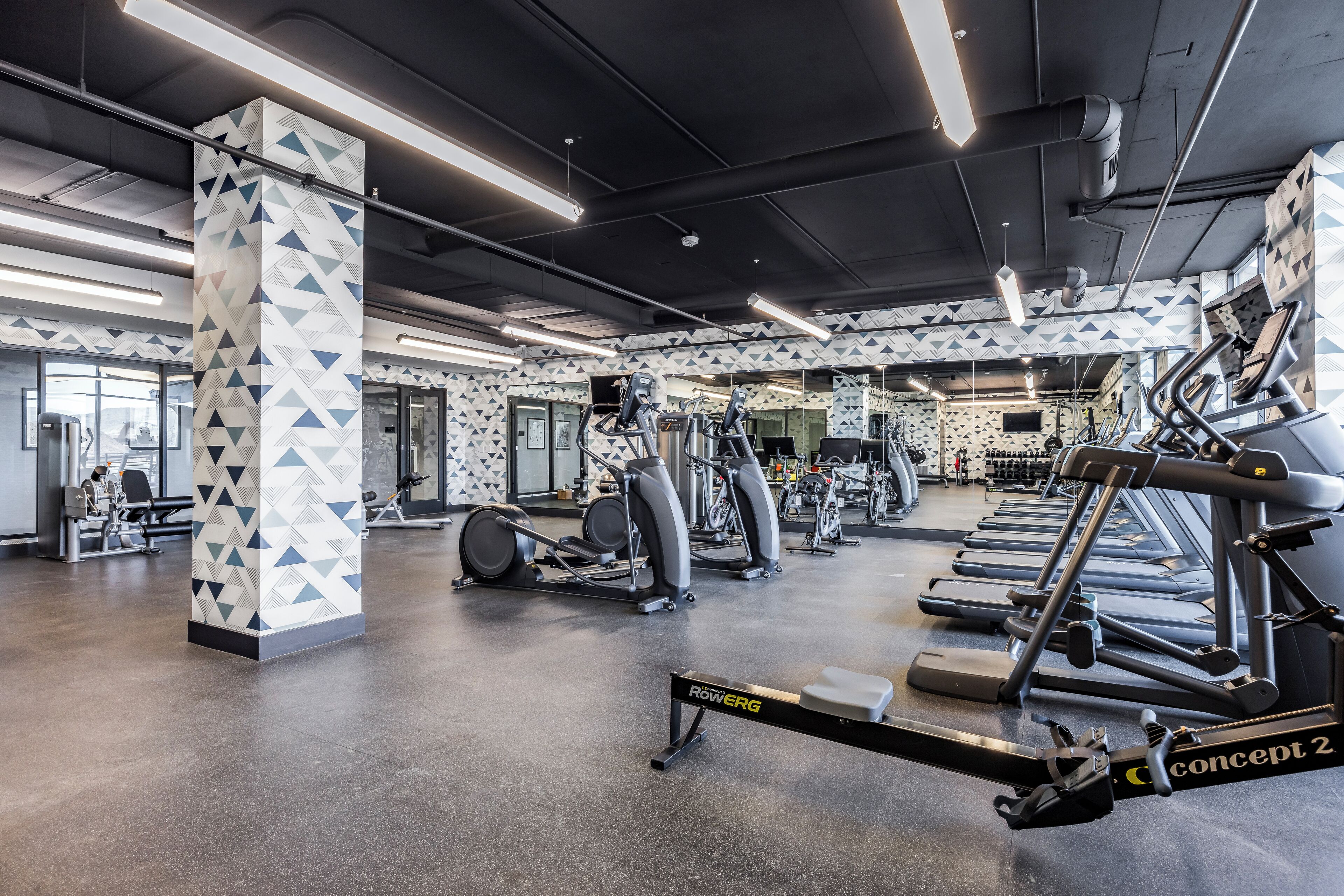 A gym with various exercise equipment, including treadmills and weight machines.