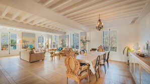 A spacious dining area with a high ceiling and large windows, wooden flooring, and a chandelier. - 2 storey luxury penthouse with large terrace but no elevator (Paris)