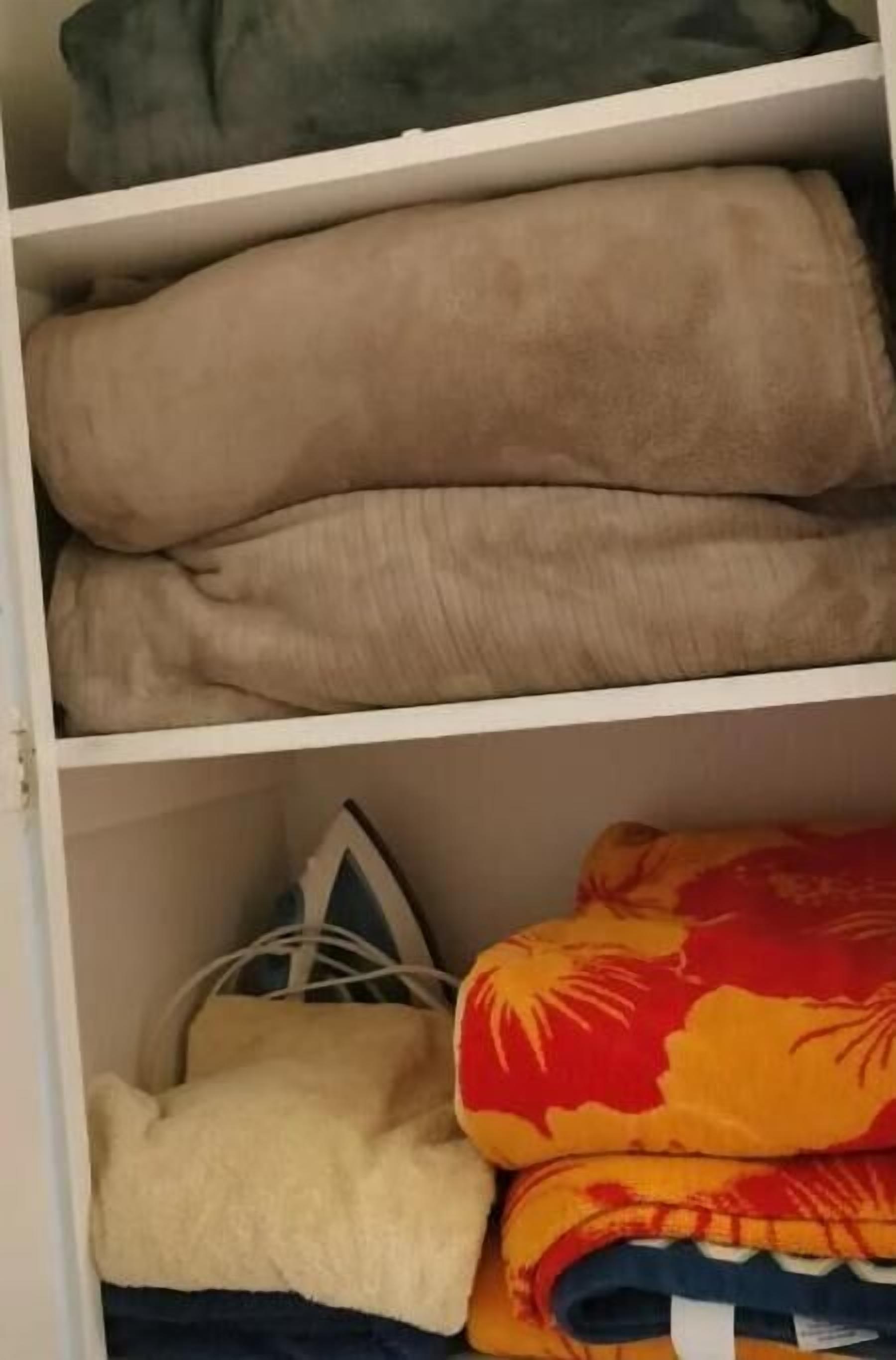 A closet with folded clothes on shelves.