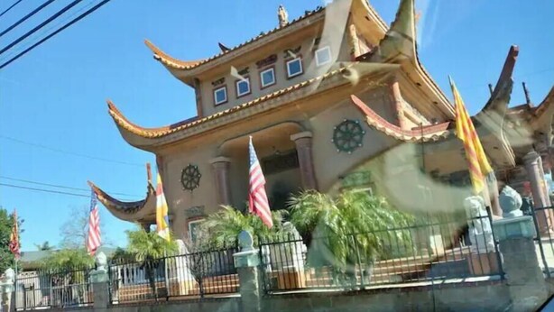 Un bâtiment traditionnel doté d’un toit incurvé et de plusieurs drapeaux.