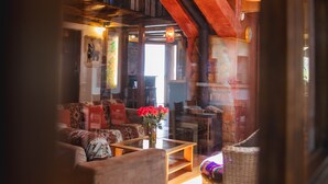 Ein gemütliches Interieur mit einer Couch, einem Korbstuhl und einem Holztisch.