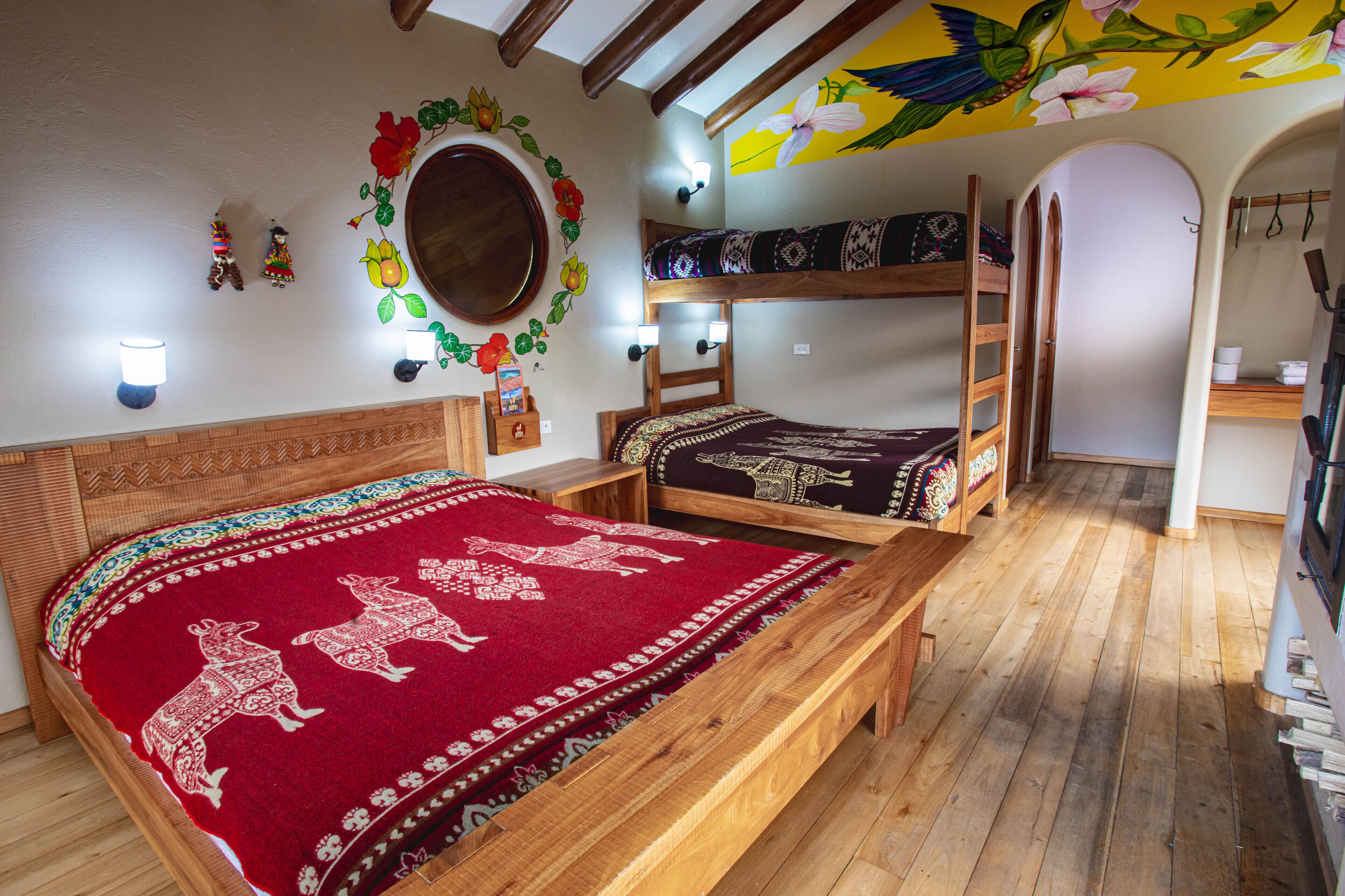 A room with a wooden bed, a bunk bed, and a bench. There are wall decorations and a mirror.