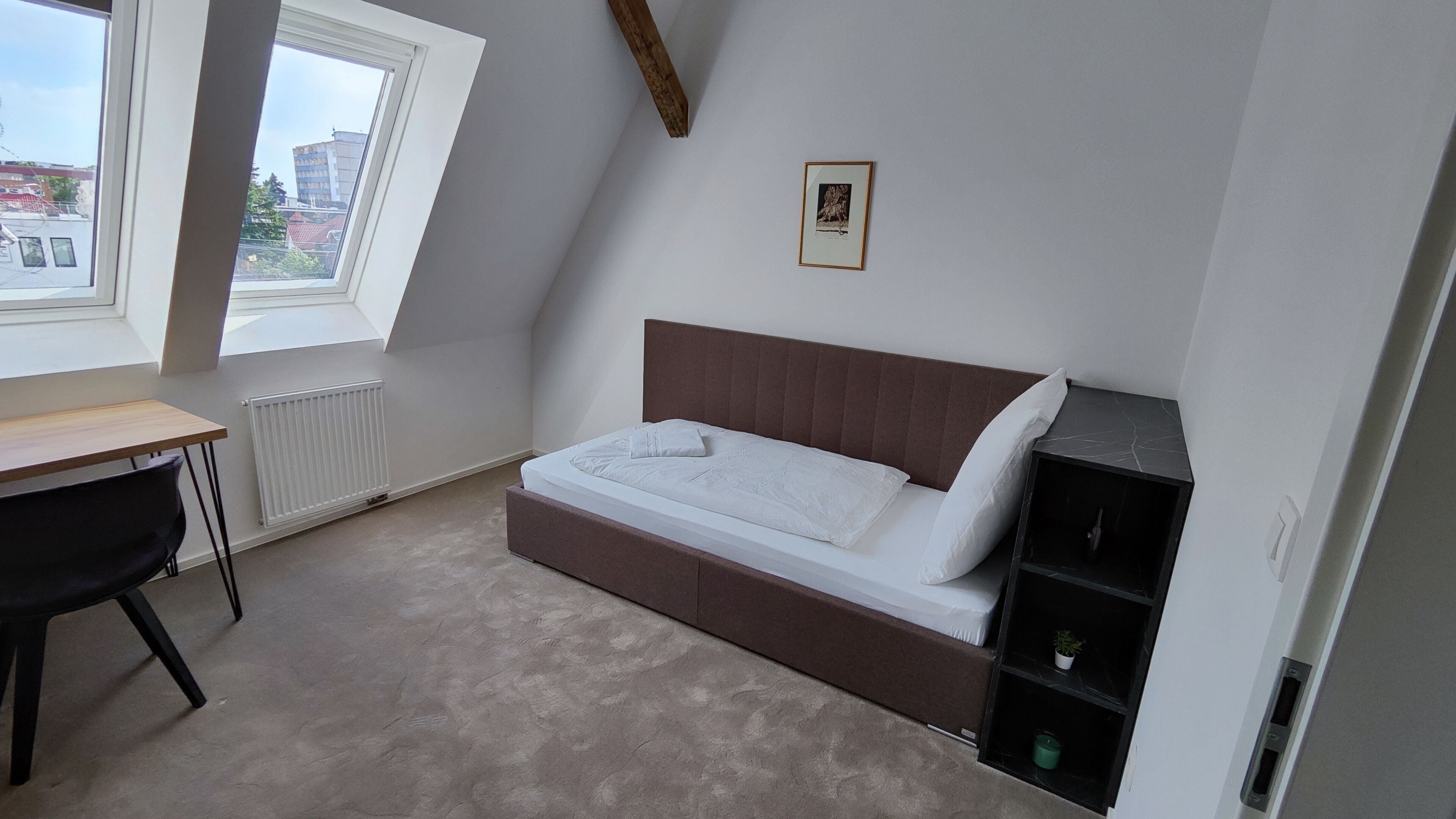 A bedroom with a loft bed, a desk, and a radiator.