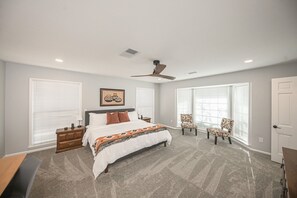 A bedroom with a bed, nightstands, a desk, and a chair. - Welcome to Twin Oaks Oasis (Midland)