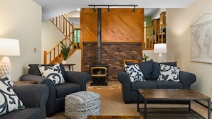 Ein Wohnzimmer mit zwei Sofas, einem Couchtisch und einem Kamin.