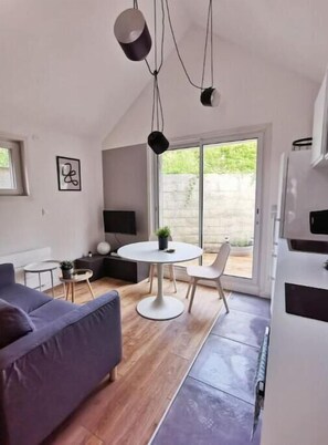 Enjoy meals and social gatherings at the round dining table near the large window, or relax on the comfortable sofa.
