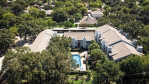 A residential building with a swimming pool, surrounded by trees. - I00 - Gated Irving 2BR | DFW 10Min | Patio + Pool (Irving)