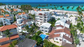 A resort with multiple buildings, a swimming pool, and a beach view. - Beachfront 8BR Villa with Pool & Maid (Punta Cana)