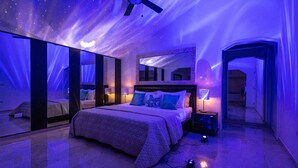 A bedroom with a bed, nightstands, a ceiling fan, and a large mirror. - Beachfront 8BR Villa with Pool & Maid (Punta Cana)