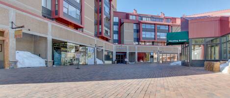 Una plaza con adoquines y un edificio moderno que muestra un cartel que dice 'Meeting Rooms'.