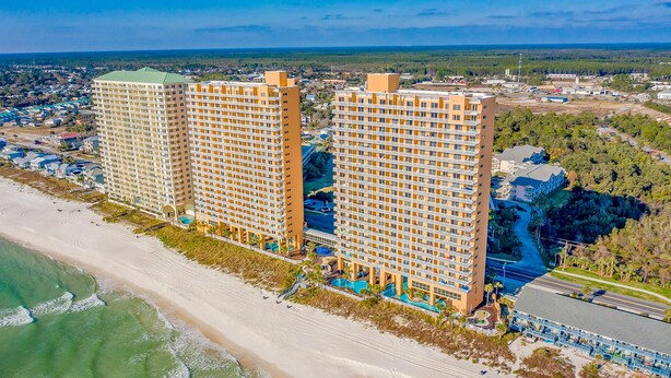 Un hôtel de grande hauteur, avec de nombreux étages, situé en bord de mer et doté d’un espace piscine.