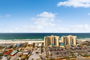 A coastal hotel with multiple buildings, a parking lot, and a beach view. - Laketown Wharf (Panama City Beach)