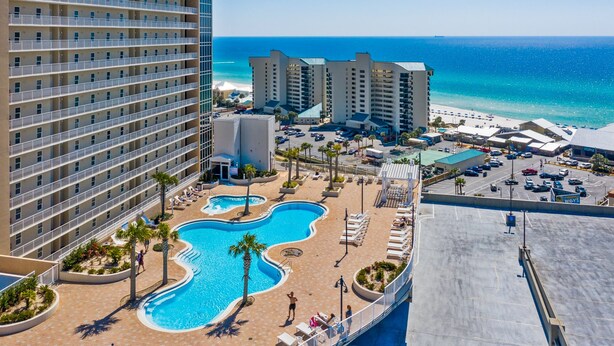 Un hotel con piscina, acceso a la playa y vistas al océano.