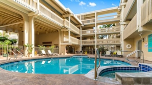 A multi-level pool area with a clear blue pool, lounge chairs, and a covered seating area. - Kona Bali Kai (Kailua-Kona)