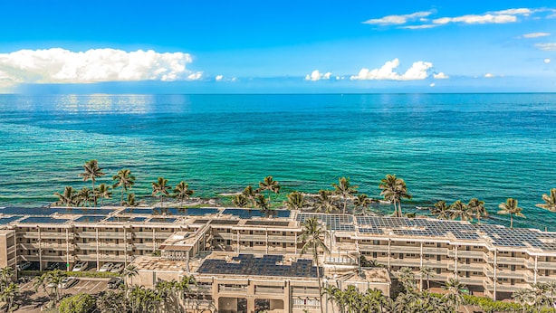 A hotel with multiple buildings, a parking lot, and a view of the ocean. - Kona Bali Kai (Kailua-Kona)