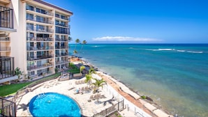 A hotel with a pool, beachside lounge, and ocean view. - Hololani Resort (Lahaina)