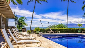 A pool area with lounge chairs and a view of the ocean. - Wavecrest (Kaunakakai)