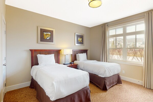 A hotel room with two beds, a window with curtains, and two framed pictures on the wall. - Rivergrass (The Blue Mountains)
