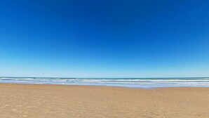 A beach with a clear blue sky and calm sea. - Suntide II Condominiums (South Padre Island)