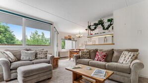 A modern living room with two sofas, a coffee table, and a dining area. - Bridges Resort (Warren)