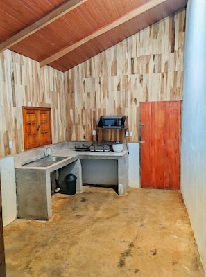 Compact kitchen area with sink, microwave, and stove.