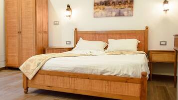 Un dormitorio con cama de madera, mesitas de noche, un armario y un cuadro en la pared.