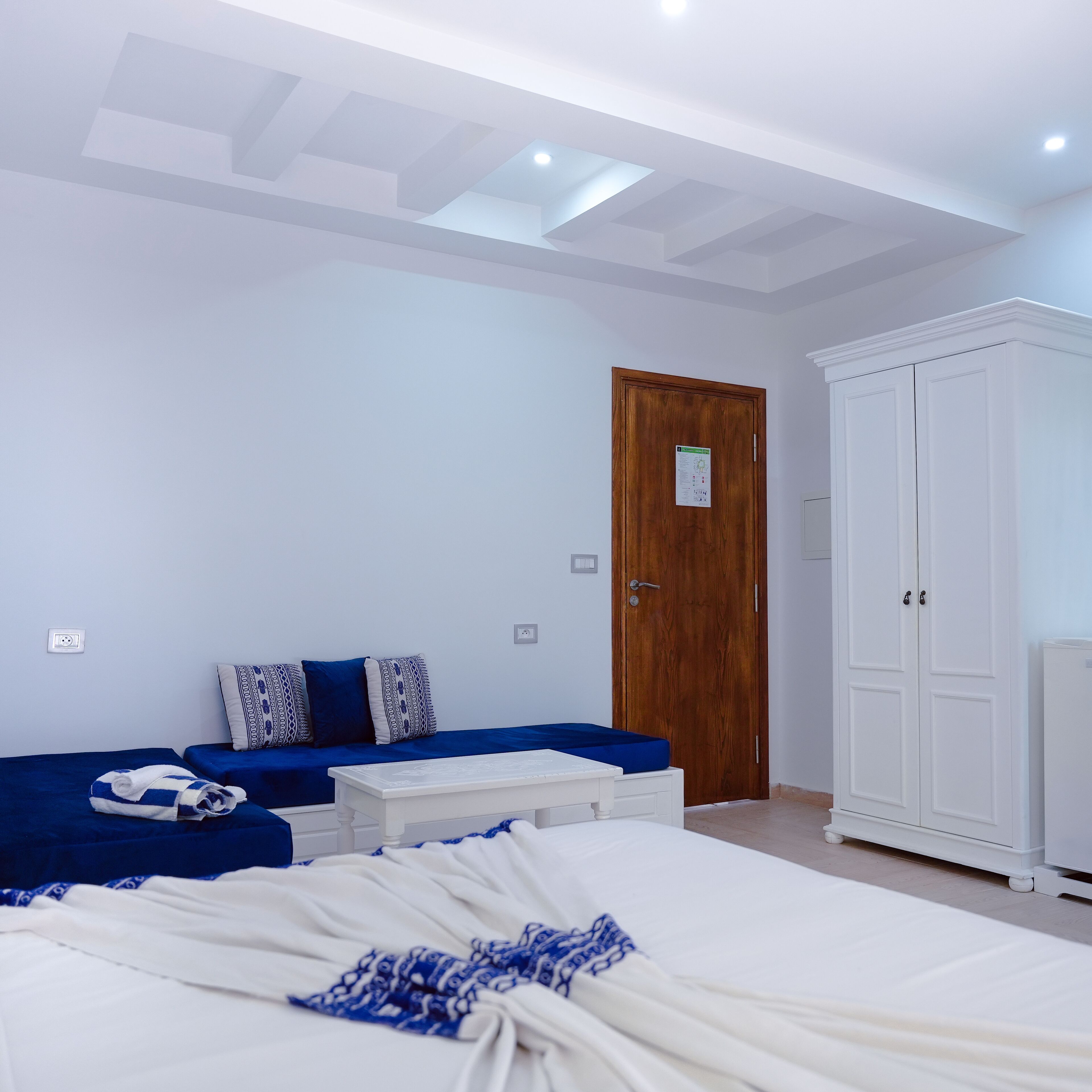 Un dormitorio con cama, sofá, armario y puerta.