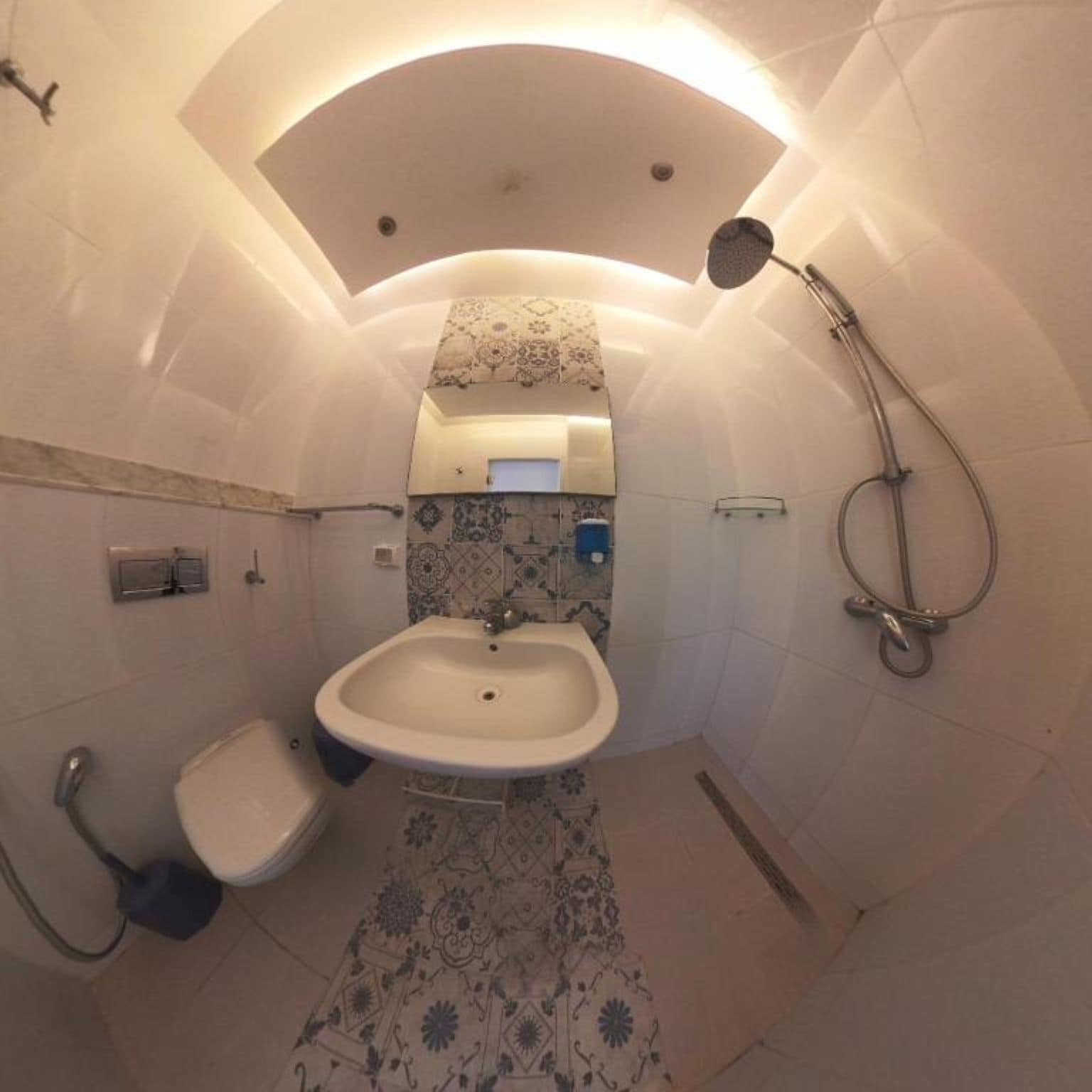 Ein kleines Badezimmer mit Waschbecken, Toilette und Dusche.