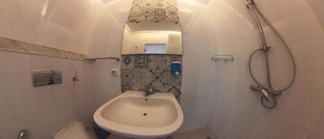 Ein kleines Badezimmer mit Waschbecken, Toilette und Dusche.