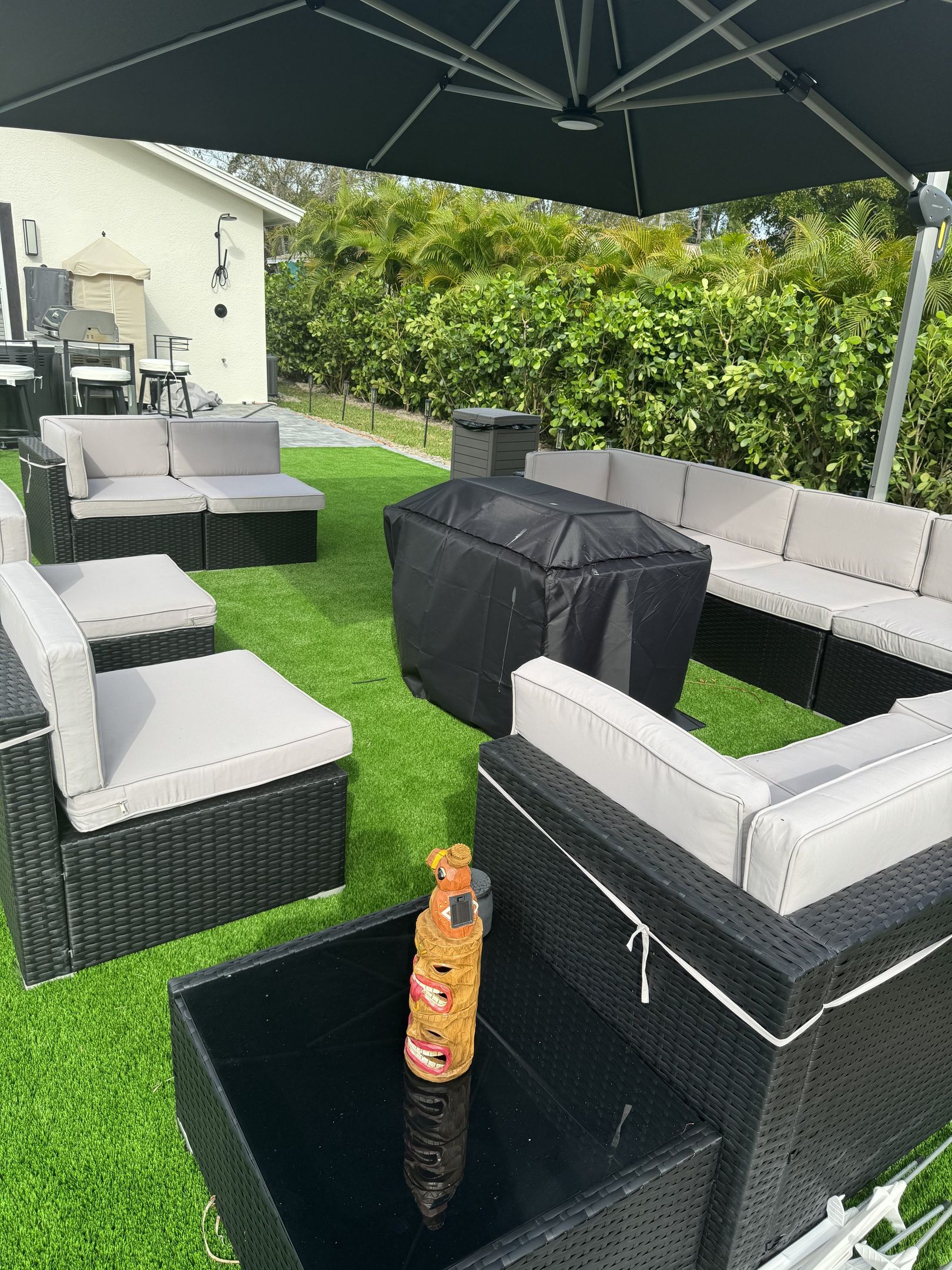 An outdoor patio area with wicker furniture, a covered table, and a bottle of orange juice.