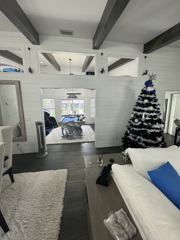 A modern living room with a large Christmas tree, a white sofa, and a view into the dining area. - JUST IN TIME FOR SEASON! (Bonita Springs)
