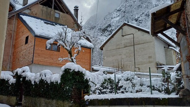 A snow-covered village with traditional wooden houses, stone walls, and a mountain in the background. - The “Cabane des Deux Soeurs”  (Le Bourg-d'Oisans)