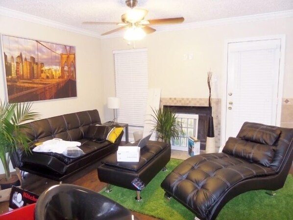 A living room with a sofa, a chair, a small table, and a fireplace.