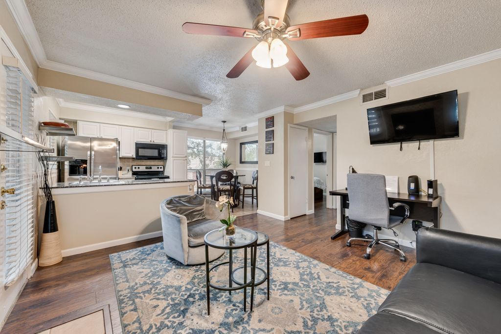 A modern living space with a kitchen, dining area, and a home office.