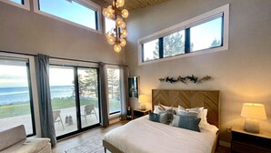 Une chambre spacieuse avec un grand lit, une vue sur l’océan et un balcon.