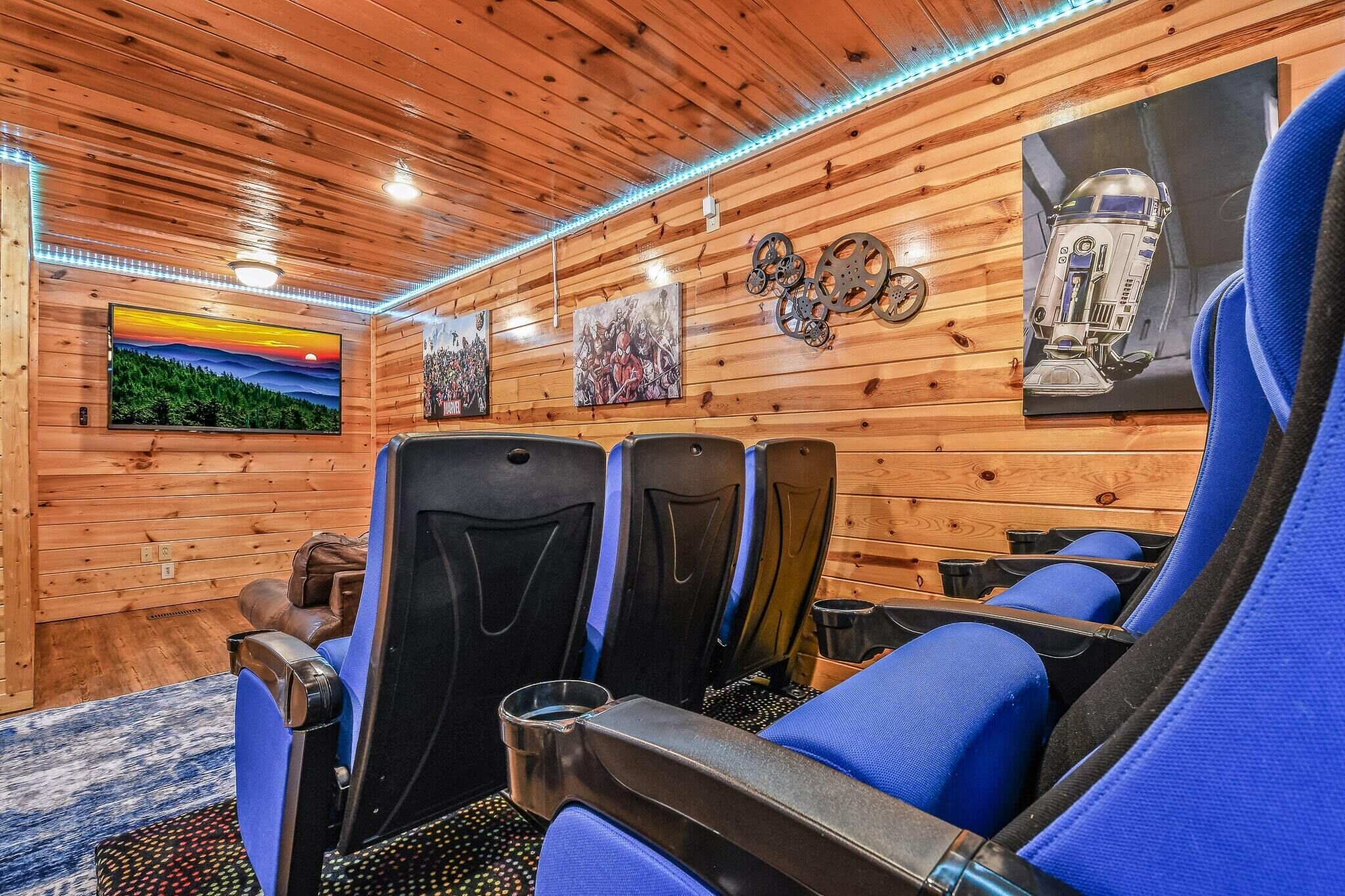A wooden interior with sauna chairs, a television, and artwork on the walls.