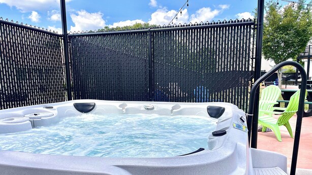 Un jacuzzi con una valla negra al fondo.