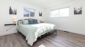 Une chambre à coucher comprenant un lit, deux tables de chevet et deux lampes fixées au mur.